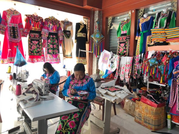 Two workers make Qiang embroidery at Chen’s clothes shop in Yanmen on May 8, 2018. (Photo by Yao Yao/chinadaily.com.cn) Two workers make Qiang embroidery at Chen’s clothes shop in Yanmen on May 8, 2018. (Photo by Yao Yao/chinadaily.com.cn)