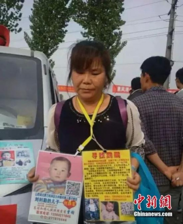 The boards Chen Zhen carries provide detailed information of her missing son, Pengpeng. (Photo/chinanews.com) The boards Chen Zhen carries provide detailed information of her missing son, Pengpeng. (Photo/chinanews.com)
