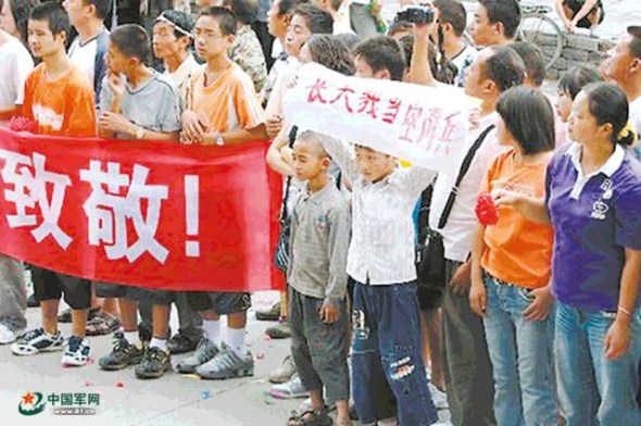 Cheng holds a banner I want to become an airborne trooper when I grow up as airborne troops leave after their rescue work in the 2008 Wenchuan earthquake. (Photo/81.cn) Cheng holds a banner I want to become an airborne trooper when I grow up as airborne troops leave after their rescue work in the 2008 Wenchuan earthquake. (Photo/81.cn)