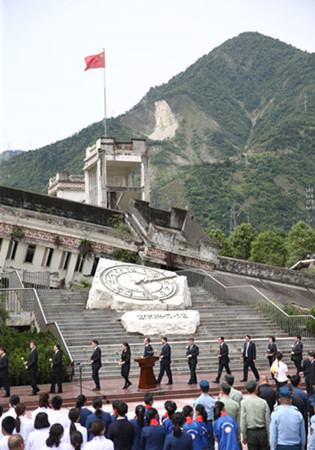 At the site of Xuankou Middle School, people gather on Saturday for a memorial service marking the 10th anniversary of the Wenchuan Earthquake in Sichuan province that killed nearly 70,000 people. [(Photo by ZOU HONG/CHINA DAILY)