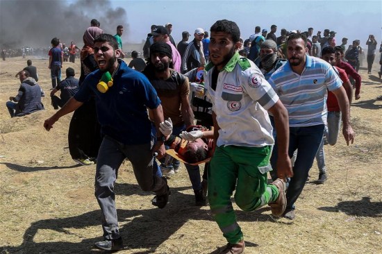 Palestinian medics and protesters carry an injured man during clashes with Israeli troops near the Gaza-Israel border, east of Gaza City, on May 14, 2018. (Xinhua/Wissam Nassar) Palestinian medics and protesters carry an injured man during clashes with Israeli troops near the Gaza-Israel border, east of Gaza City, on May 14, 2018. (Xinhua/Wissam Nassar)