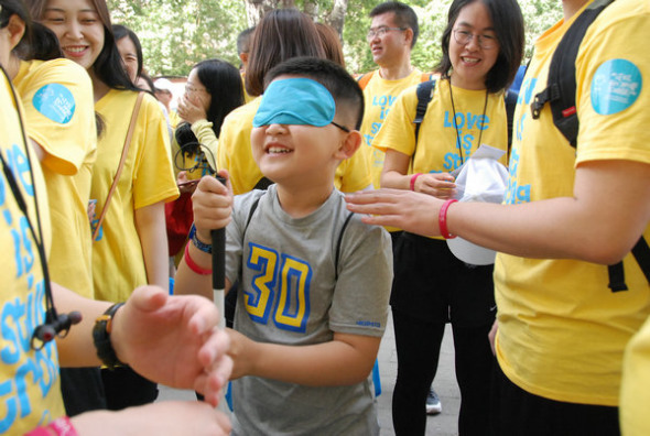A boy at the Wishbone Day event walk with his eyes covered to experience OI which may affect eyesight in some cases. (Photo provided to China Daily) A boy at the Wishbone Day event walk with his eyes covered to experience OI which may affect eyesight in some cases. (Photo provided to China Daily)