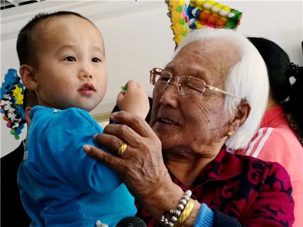 Jing plays with a child at a children's welfare house in Changchun, to which she donated 10,000 yuan. (Photo provided to China Daily)