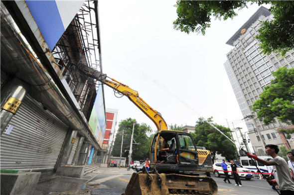 An excavator tears into the Guang'anzhonghai electronics market in Beijing earlier this month as another worker uses a water hose to dampen the dust. (WANG JIANKANG/FOR CHINA DAILY) An excavator tears into the Guang'anzhonghai electronics market in Beijing earlier this month as another worker uses a water hose to dampen the dust. (WANG JIANKANG/FOR CHINA DAILY)