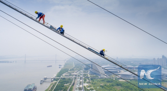 Workers install wire netting upon catwalk for the construction of a bridge across the Yangtze River in Wuhan, capital of central China's Hubei Province, May 8, 2018. (Xinhua/Ke Hao) Workers install wire netting upon catwalk for the construction of a bridge across the Yangtze River in Wuhan, capital of central China's Hubei Province, May 8, 2018. (Xinhua/Ke Hao)