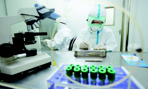 Quarantine workers at Qingdao airport in Shandong province test samples for the Ebola virus on Aug. 11, 2014. (Xie Hao/For China Daily)