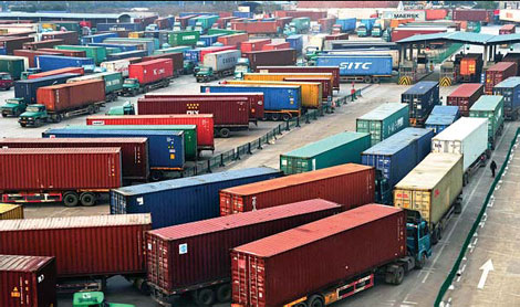Container trucks wait to clear customs at an international shipping center in Yiwu city, Zhejiang province. [Xinhua]