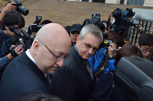 Representatives of Apple are surrounded by the media before they attend a court hearing on the iPad trademark dispute outside the Higher People's Court of south China's Guangdong Province in Guangzhou on Wednesday, February 29th, 2012. [Photo: Chinanews.com]