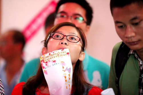 A jobseeker checks out job information attentively at a job fair for college graduates in Bozhou, Anhui province, Aug 18, 2012. A study found that working for a State-owned enterprise of local privately owned companies is becoming increasingly attractive,