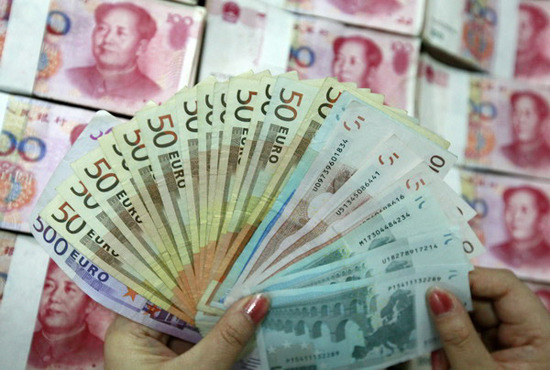 A clerk displays euro and yuan banknotes at an Industrial and Commercial Bank of China Co Ltd branch in Huaibei, Anhui province. (Photo: China Daily)