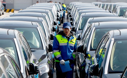 An inspector walks among imported vehicles at Shanghai’s Waigaoqiao port. China imported 79,800 vehicles in November, down 26.1 percent year-on-year. PEI XIN / XINHUA