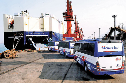 A freight vessel being loaded with passenger coaches for export to Cuba at a port in Lianyungang, Jiangsu province. China's auto exports surpassed 1 million vehicles in 2012. Wang Chun / For China Daily 