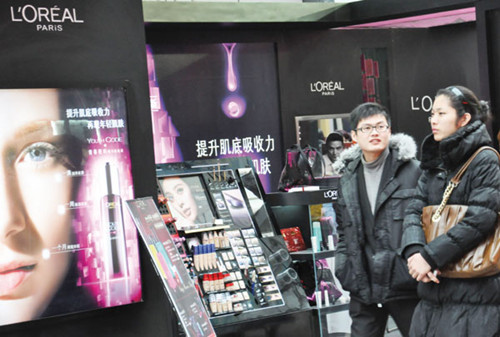 Shoppers walk along a L'Oreal sales center at a shopping mall in Qingdao, Shandong province. [Photos/China Daily]