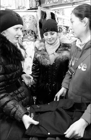 A Russian woman bargaining with a Chinese clothes dealer in a shopping plaza in Raohe county, Heilongjiang province. After accession to the WTO, many Chinese economists believe China has more opportunities to increase its business relations with Russia in the years to come. [Photo/China Daily]