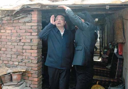 Premier Li Keqiang checks the ceiling of a resident's home in Tienan, a shantytown in Chifeng, Inner Mongolia autonomous region, on Thursday. Liu Zhen / China News Service
