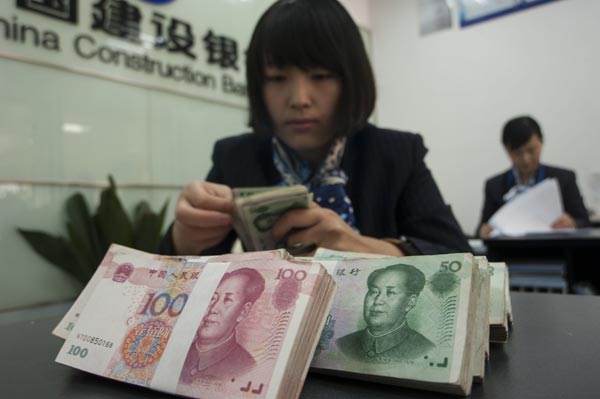 A clerk at an outlet of China Construction Bank Corp in Hai'an, Jiangsu province. Statistics show that the problem of nonperforming loans expanded in 2014 from the Yangtze and Pearl river regions into western China. (Photo/China Daily)