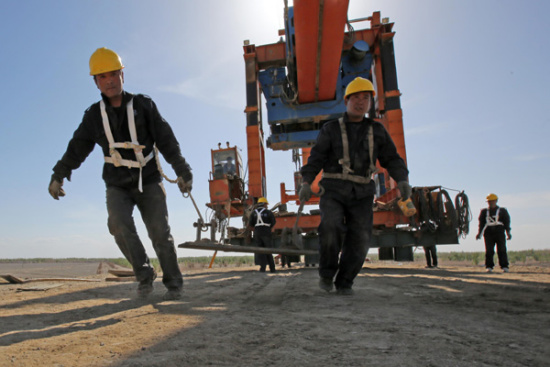 Workers prepare for the construction of a bridge over the Ejina-Hami railway in the Xinjiang Uygur autonomous region last week. (Photo/China Daily) Workers prepare for the construction of a bridge over the Ejina-Hami railway in the Xinjiang Uygur autonomous region last week. (Photo/China Daily)