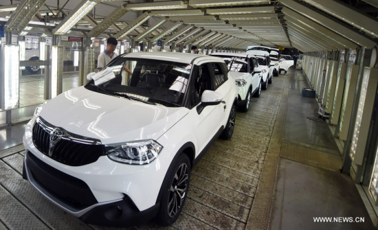 Workers examine cars at the general assembly shop of Zhonghua cars of Huachen Auto Group in Shenyang, capital of northeast China's Liaoning Province, June 10, 2015. (Photo: Xinhua/Yang Qing)
