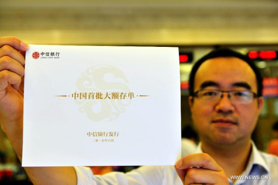 A staff member of China Citic Bank displays a certificate of deposit (CD) in Hangzhou, capital of east China's Zhejiang Province, June 15, 2015. (Photo: Xinhua/Long Wei) A staff member of China Citic Bank displays a certificate of deposit (CD) in Hangzhou, capital of east China's Zhejiang Province, June 15, 2015. (Photo: Xinhua/Long Wei)