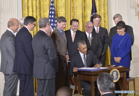 U.S. President Barack Obama signs acts in the East Room of the White House in Washington, D.C., the United States, on June 29, 2015. (Photo: Xinhua/Yin Bogu)