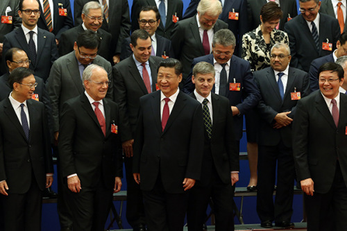 President Xi Jinping joins with envoys of governments that signed onto the Chinese-led Asian Infrastructure Investment Bank at the Great Hall of the People in Beijing on Monday. (Photo/China Daily) President Xi Jinping joins with envoys of governments that signed onto the Chinese-led Asian Infrastructure Investment Bank at the Great Hall of the People in Beijing on Monday. (Photo/China Daily)