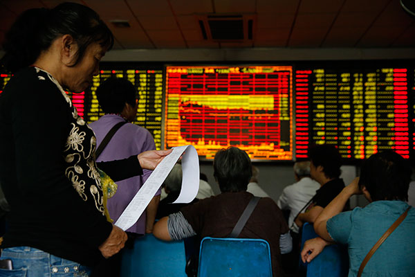 An investor checks her trading records at a brokerage in Shanghai on Tuesday. The benchmark Shanghai Composite Index has fallen by about 30 percent in the past three weeks. (Photo/China Daily) An investor checks her trading records at a brokerage in Shanghai on Tuesday. The benchmark Shanghai Composite Index has fallen by about 30 percent in the past three weeks. (Photo/China Daily)