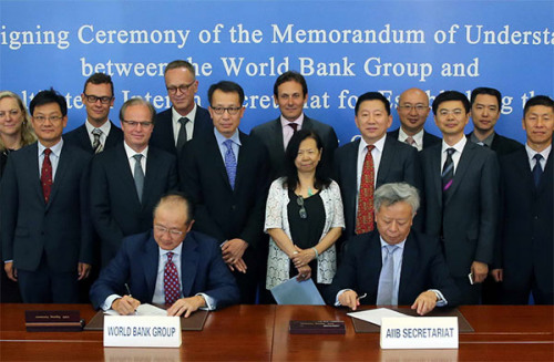 Jin Liqun (right), secretary-general of the AIIB Multilateral Interim Secretariat, and Jim Yong Kim, president of the World Bank, sign cooperation agreements between the two institutions in Beijing on Thursday. (Photo/China Daily) Jin Liqun (right), secretary-general of the AIIB Multilateral Interim Secretariat, and Jim Yong Kim, president of the World Bank, sign cooperation agreements between the two institutions in Beijing on Thursday. (Photo/China Daily)