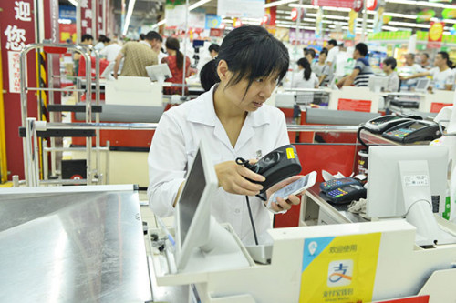 A shop assistant at a supermarket in Hangzhou, capital of Zhejiang province, scans QR code on a buyer's mobile phone. Leading Internet companies are scrambling to expand their offline operations by linking up with traditional brand name retailers. (Photo/China Daily) A shop assistant at a supermarket in Hangzhou, capital of Zhejiang province, scans QR code on a buyer's mobile phone. Leading Internet companies are scrambling to expand their offline operations by linking up with traditional brand name retailers. (Photo/China Daily)