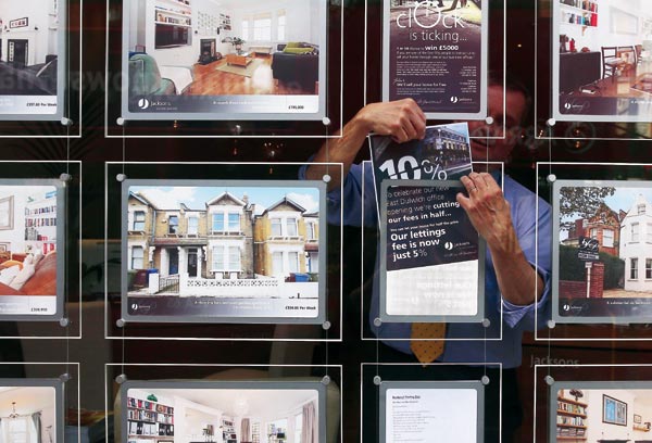 A Jacksons Estate Agent employee hangs a promotional sign in Dulwich, London. (Photo / Provided to China Daily) A Jacksons Estate Agent employee hangs a promotional sign in Dulwich, London. (Photo / Provided to China Daily)