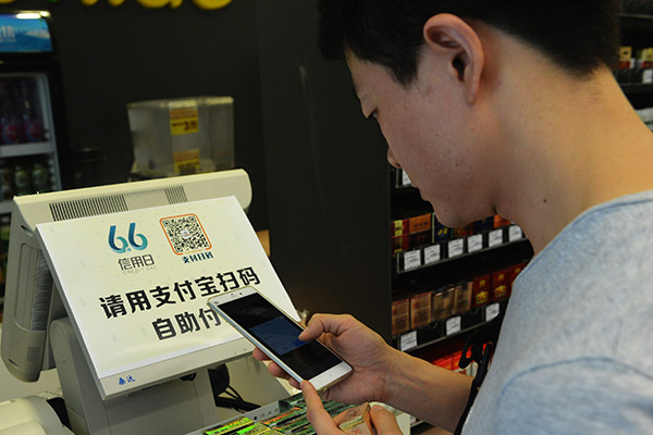 A man uses his smartphone to scan a Alipay two-dimensional code for payments at the first unmanned supermarket in Hangzhou, Zhejiang province. (Asianewsphoto by Long Wei) A man uses his smartphone to scan a Alipay two-dimensional code for payments at the first unmanned supermarket in Hangzhou, Zhejiang province. (Asianewsphoto by Long Wei)