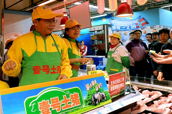 Chen Sheng (left), president of Tiandi No 1, a newly listed company on the New Third Board, promotes his No 1 Original Pig products at a supermarket in Beijing. The company plans to issue an additional 25 million shares for 25 yuan each to raise 625 million yuan. (Photo/China Daily) Chen Sheng (left), president of Tiandi No 1, a newly listed company on the New Third Board, promotes his No 1 Original Pig products at a supermarket in Beijing. The company plans to issue an additional 25 million shares for 25 yuan each to raise 625 million yuan. (Photo/China Daily)