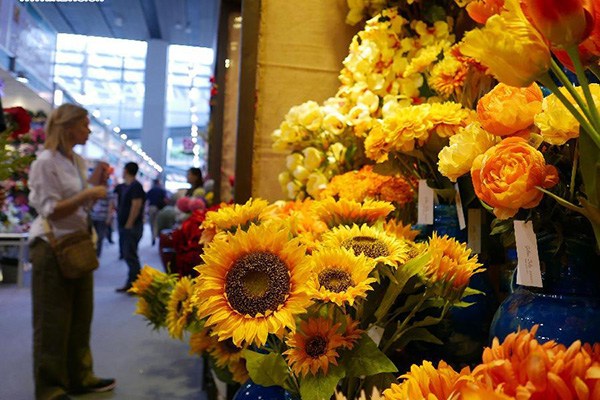 A woman views artificial flowers during the China Import and Export Fair, or the Canton Fair, in Guangzhou, capital of South China's Guangdong province, Oct 26, 2015. (Photo/Xinhua) A woman views artificial flowers during the China Import and Export Fair, or the Canton Fair, in Guangzhou, capital of South China's Guangdong province, Oct 26, 2015. (Photo/Xinhua)