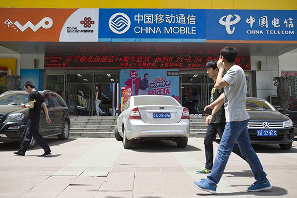 Pedestrians walk past a telecom services outlet in Taiyuan, Shanxi province. Shares of China United Network Communications Ltd surged by 6.96 percent to 7.07 yuan ($1.1) on Nov 5, 2015. (Photo/China Daily) Pedestrians walk past a telecom services outlet in Taiyuan, Shanxi province. Shares of China United Network Communications Ltd surged by 6.96 percent to 7.07 yuan ($1.1) on Nov 5, 2015. (Photo/China Daily)