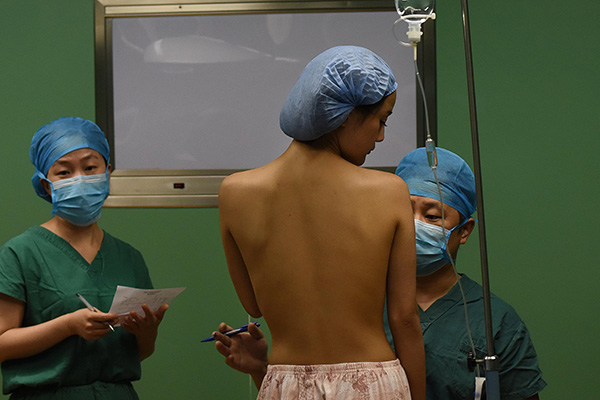 A doctor prepares a patient for breast-enhancement surgery at a hospital in Hefei, Anhui province, in July. (Photo/China Daily) A doctor prepares a patient for breast-enhancement surgery at a hospital in Hefei, Anhui province, in July. (Photo/China Daily)