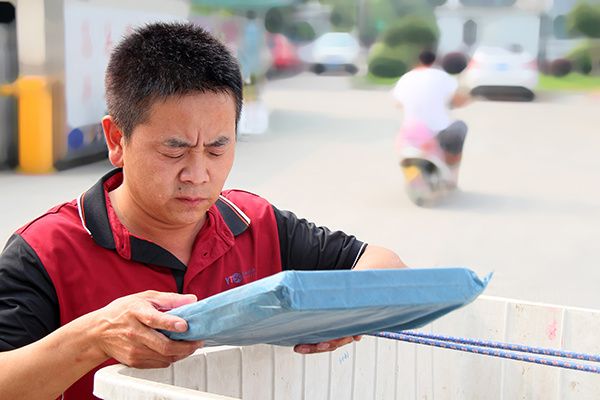 A Shanghai YTO employee checks a parcel's address to make sure it is correct. (Photo provided to China Daily) A Shanghai YTO employee checks a parcel's address to make sure it is correct. (Photo provided to China Daily)