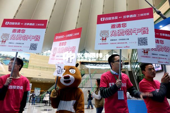 Staff of Baidu Waimai hold placards, reading You're invited to enjoy a free lunch, in a convention center in Zhengzhou, Henan province. (Photo/China Daily) Staff of Baidu Waimai hold placards, reading You're invited to enjoy a free lunch, in a convention center in Zhengzhou, Henan province. (Photo/China Daily)