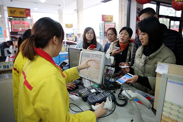 People enjoy a 85 percent discount by paying for their vehicle fuel with Alipay Wallets at a gas station in Shaoxing, Zhejiang province.(Photo/China Daily) People enjoy a 85 percent discount by paying for their vehicle fuel with Alipay Wallets at a gas station in Shaoxing, Zhejiang province.(Photo/China Daily)