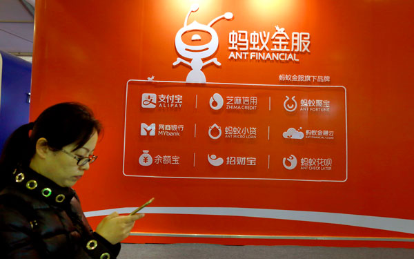 A woman walks past an advertisement for Ant Financial Services Group in Wuzhen, Zhejiang province. Spun off from Alibaba in 2011, the company runs Alipay, China's largest online payment service provider with 270 million monthly active users.(Photo/China Daily)