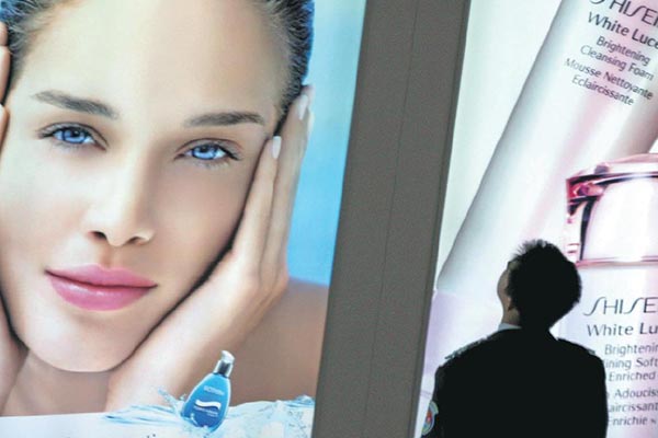 A man checks out a Shiseido Co Ltd's beauty products advertisement in Beijing. The Japanese company's China business grew by only 2 percent last year.(Provided to China Daily)