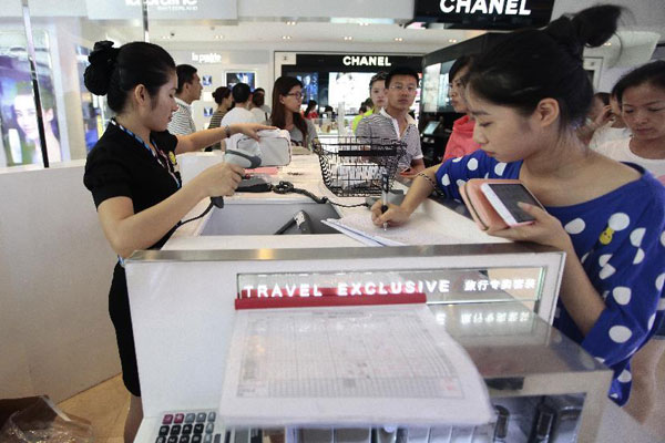Tourists select products at a duty free shop (DFS) in Sanya, south China's tourist destination Hainan Province, April 23, 2014. (Photo/Xinhua) Tourists select products at a duty free shop (DFS) in Sanya, south China's tourist destination Hainan Province, April 23, 2014. (Photo/Xinhua)