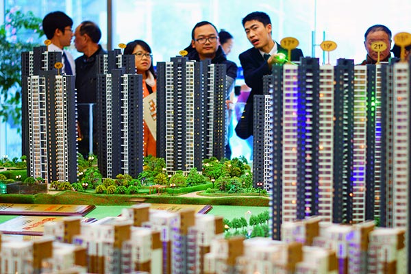 Potential customers look at a model of a real estate development in Yichang, Hubei province.(ZHOU JIANPING / FOR CHINA DAILY) Potential customers look at a model of a real estate development in Yichang, Hubei province.(ZHOU JIANPING / FOR CHINA DAILY)