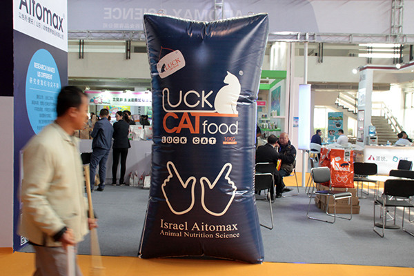 A man passes by a giant cat food advertisement at a pet food and necessities fair in Beijing. (Photo/China Daily) A man passes by a giant cat food advertisement at a pet food and necessities fair in Beijing. (Photo/China Daily)