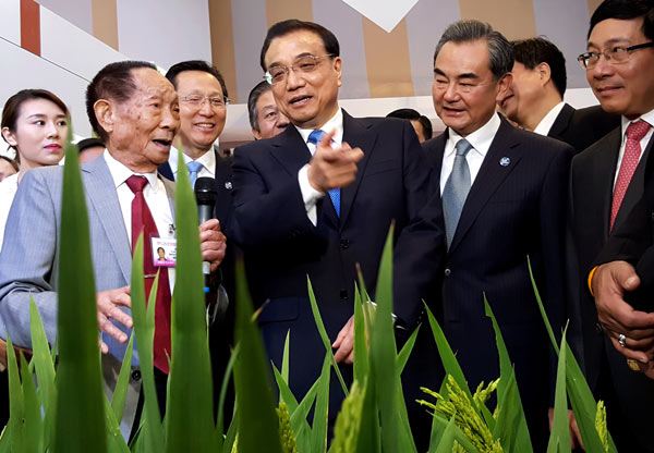 Premier Li Keqiang consults with Yuan Longping (left), known as the father of hybrid rice, during an exhibition on Lancang-Mekong cooperation in Sanya, Hainan province, on Wednesday. WU ZHIYI / CHINA DAILY Premier Li Keqiang consults with Yuan Longping (left), known as the father of hybrid rice, during an exhibition on Lancang-Mekong cooperation in Sanya, Hainan province, on Wednesday. WU ZHIYI / CHINA DAILY