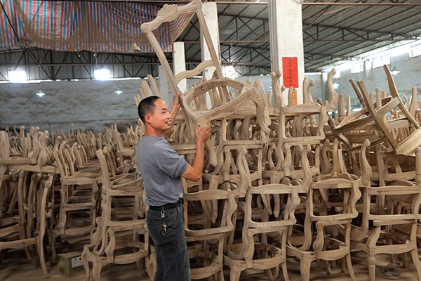 A worker carries an unpainted chair in a furniture factory in Dongguan, Guangdong province. The traditional Chinese-style furniture is mainly for export. (Photo provided to China Daily) A worker carries an unpainted chair in a furniture factory in Dongguan, Guangdong province. The traditional Chinese-style furniture is mainly for export. (Photo provided to China Daily)
