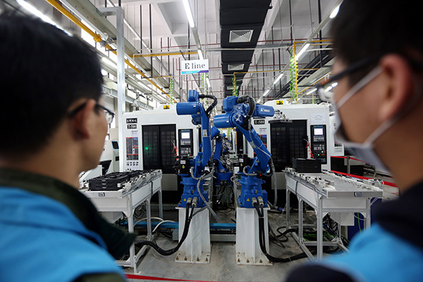 Two workers inspect a production line equipped with robots in Dongguan. (Photo/China Daily) Two workers inspect a production line equipped with robots in Dongguan. (Photo/China Daily)