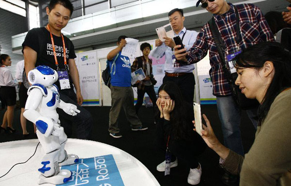 Visitors watch a robot dancing at the 2015 International Consumer Electronics Show (CES) Asia in Shanghai, May 27, 2015. (Photo/Xinhua) Visitors watch a robot dancing at the 2015 International Consumer Electronics Show (CES) Asia in Shanghai, May 27, 2015. (Photo/Xinhua)