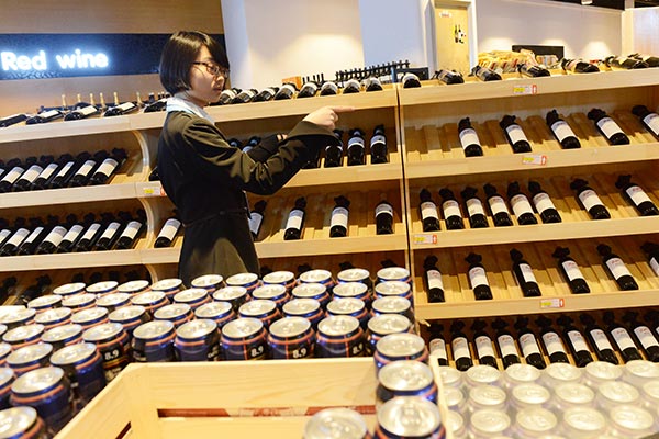 A customer chooses wine at a cross-border duty-free shop at the Zhengzhou airport, Henan province. ZHANG TAO / FOR CHINA DAILY A customer chooses wine at a cross-border duty-free shop at the Zhengzhou airport, Henan province. ZHANG TAO / FOR CHINA DAILY