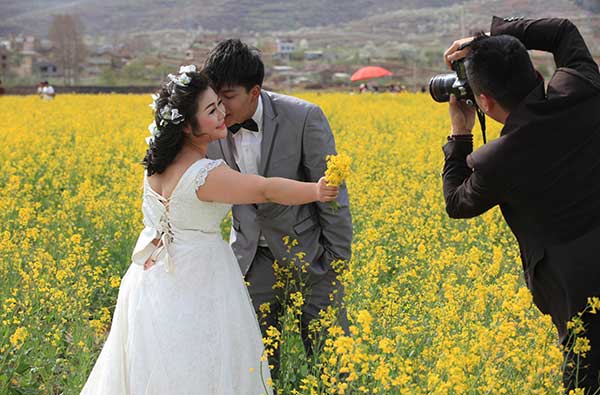 A newlywed couple has their picture taken in a rapeseed field in Zhaotong city, Yunnan province.Zhang Guangyu / For China Daily A newlywed couple has their picture taken in a rapeseed field in Zhaotong city, Yunnan province.Zhang Guangyu / For China Daily