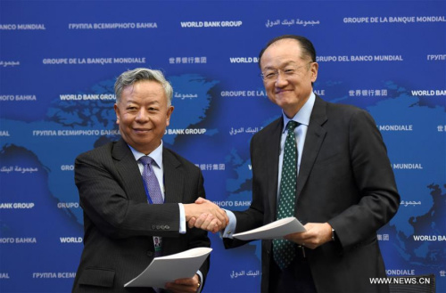 World Bank President Jim Yong Kim (R) and Asian Infrastructure Investment Bank (AIIB) President Jin Liqun shake hands after signing the first co-financing framework agreement at the headquarters of World Bank in Washington D.C., the United States, April 13, 2016. World Bank and the AIIB on Wednesday signed the first co-financing framework agreement, paving the way for their cooperation on joint projects this year. (Photo: Xinhua/Yin Bogu) World Bank President Jim Yong Kim (R) and Asian Infrastructure Investment Bank (AIIB) President Jin Liqun shake hands after signing the first co-financing framework agreement at the headquarters of World Bank in Washington D.C., the United States, April 13, 2016. World Bank and the AIIB on Wednesday signed the first co-financing framework agreement, paving the way for their cooperation on joint projects this year. (Photo: Xinhua/Yin Bogu)