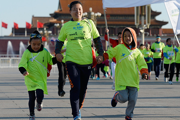 A mother and her two children join an international running festival in Beijing. The event attracted more than 20,000 participants. (Photo/China Daily) A mother and her two children join an international running festival in Beijing. The event attracted more than 20,000 participants. (Photo/China Daily)